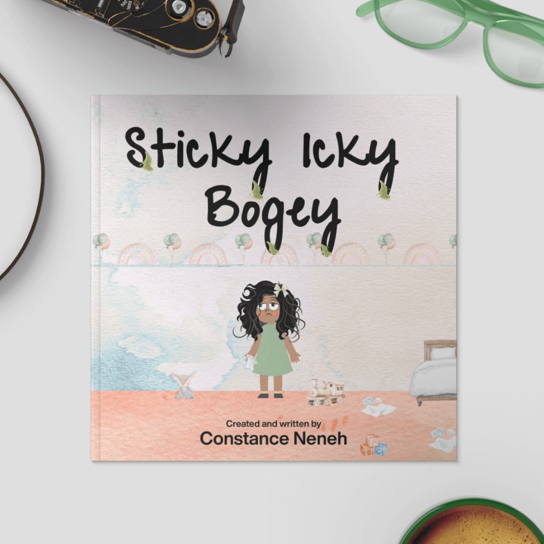 Book titled 'Sticky Icky Bogey' by Constance Neneh on a white surface with a camera and glasses in the background.